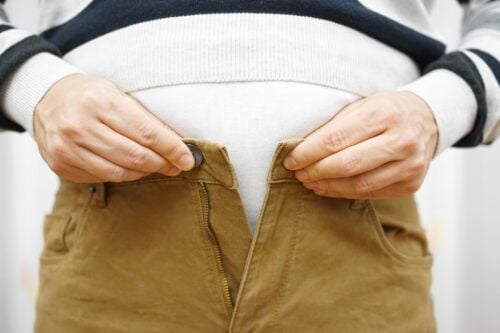 5 Nutrient Deficiencies That Make You Overeat man is unable to close his pants because of gaining weight