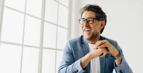 12 Foods That Are Ruining Your Smile Business man looking outside the window in an office. Senior business man thinking about work while sitting at his desk in a suit.