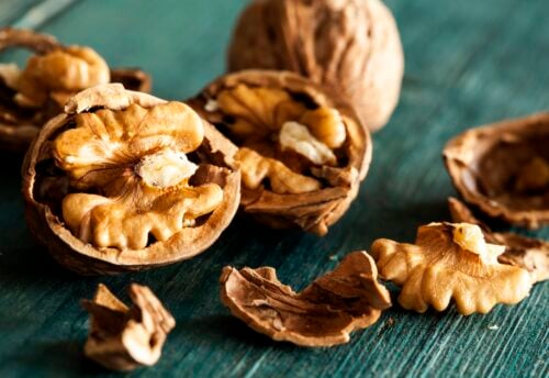 Walnut Consumption to Lower Depression Scores Walnuts on wooden table