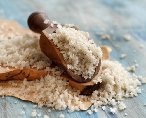 10 Celtic Sea Salt Benefits Celtic Grey Sea Salt with a spoon on a blue wooden table